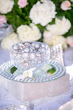 Gümüş kaplama ceviz ve bademlerden oluşan bir düğün dekoru ve geleneksel İran dekoruyla birlikte cam bir kase ve tepsi.