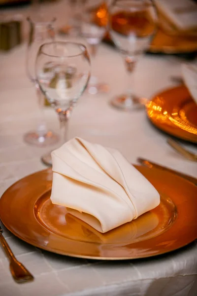 結婚式のディナーのための伝統的な黄金のガラスプレートとテーブルの設定 — ストック写真