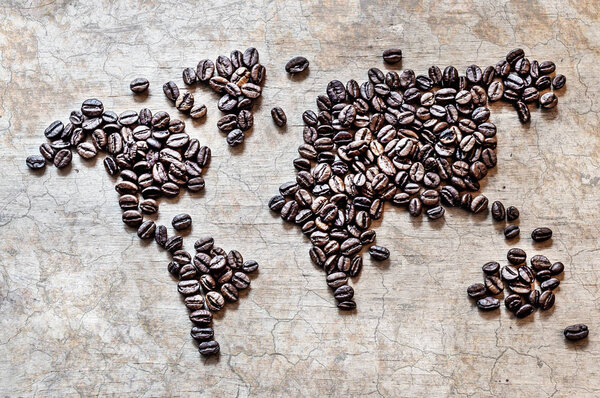 Map of continents from coffee beans on an old wooden background