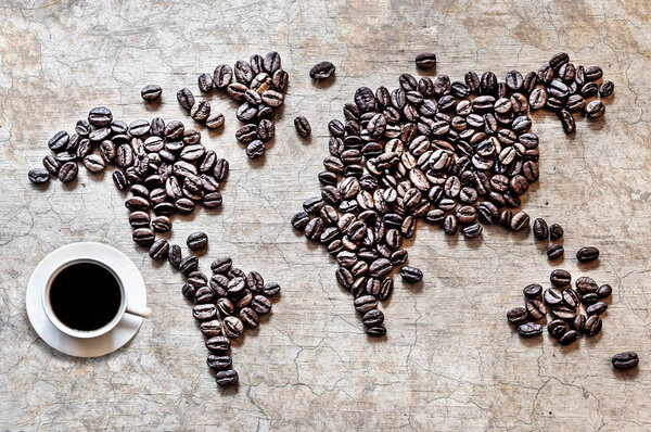 Map of continents from coffee beans on an old wooden background