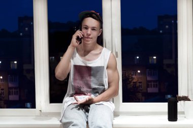 pencere pencere yanında oturan telefonda konuşan şık genç adam