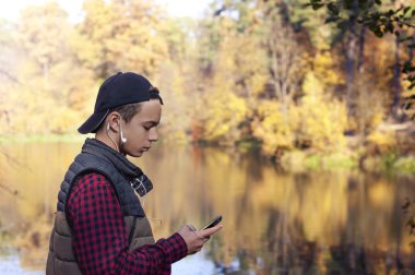 üzgün genç adam bir sonbahar parkında bir ileti yazar