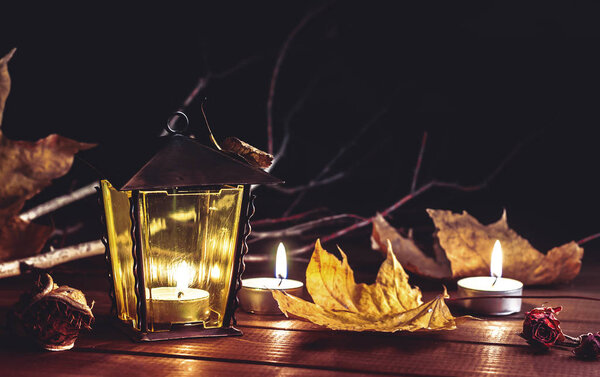 свечи, старый фонарь, осенние листья на деревянном столе
