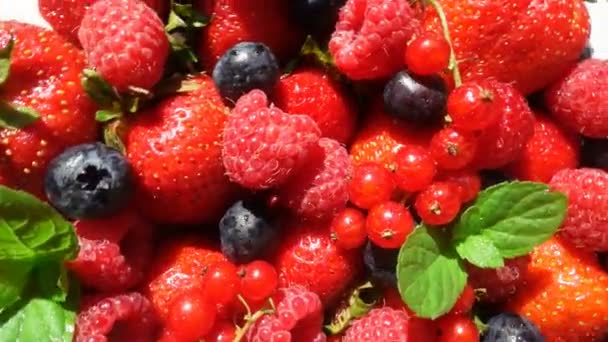 Rote reife Gartenerdbeeren und Blaubeeren, Rotation der Beeren auf weißem Tisch, schöner Hintergrund — Stockvideo