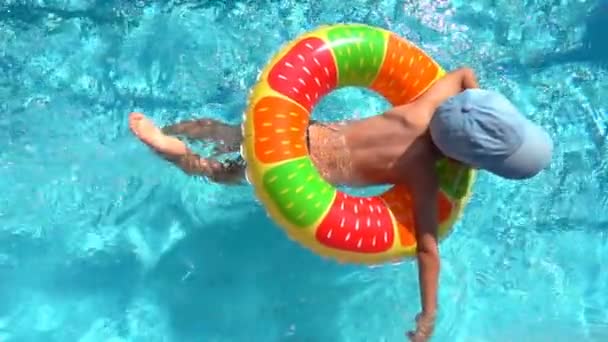 Barnet simmar i poolen med en uppblåsbar cirkel, Slowmotion — Stockvideo