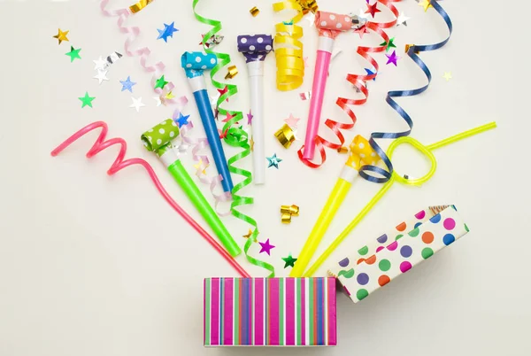 Geschenkbox mit verschiedenen Party-Konfetti, Luftballons, Luftschlangen, Krachmachern und Dekoration auf grünem Hintergrund. Farbenfrohe Feier Hintergrund. — Stockfoto