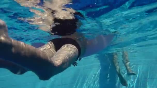 The child swims in the pool with an inflatable circle, slow motion — Stock Video