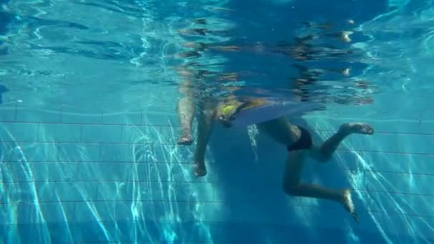 El niño nada en la piscina con un círculo inflable, cámara lenta — Vídeo de stock