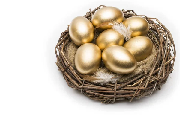 Ninho com ovos dourados sobre um fundo branco. Ovos de ouro no ninho — Fotografia de Stock