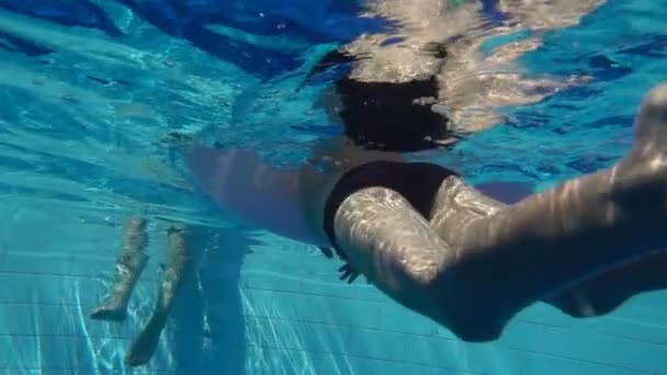 L'enfant nage dans la piscine avec un cercle gonflable, au ralenti — Video