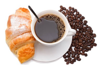 kruvasan ve kahve çekirdekleri üzerinde beyaz bir arka plan ile kahve kupa