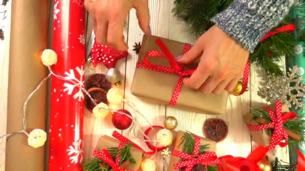 Mulher está embrulhando presentes de Natal na mesa, conceito de se preparar para o Ano Novo e feriados de Natal — Vídeo de Stock