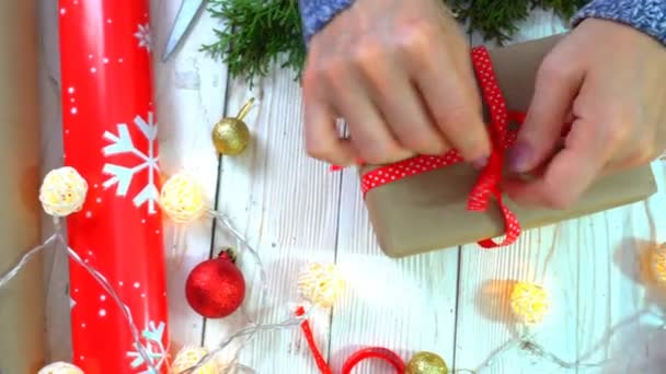 Kvinnan inslagning julklappar på bordet, begreppet förberedelser för nyår och jul semester — Stockvideo
