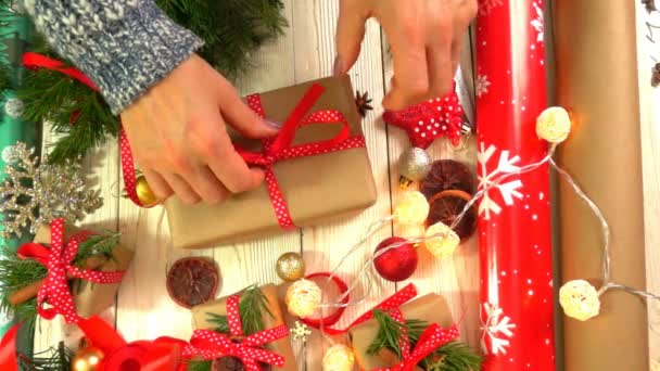 Kvinnan inslagning julklappar på bordet, begreppet förberedelser för nyår och jul semester — Stockvideo