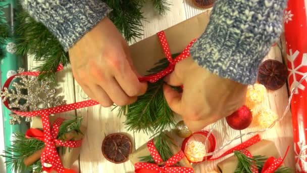 Mujer está envolviendo regalos de Navidad sobre la mesa, concepto de preparación para el Año Nuevo y las vacaciones de Navidad — Vídeo de stock