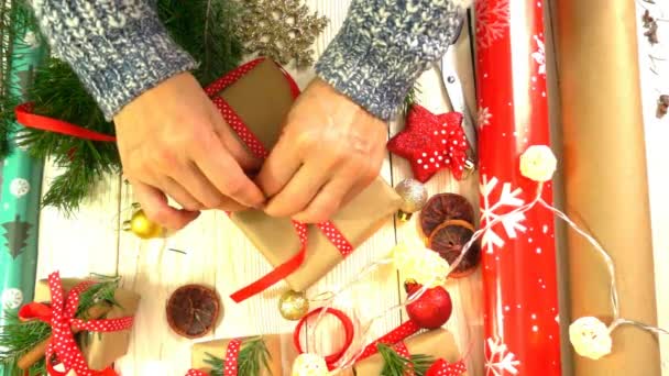 Mujer está envolviendo regalos de Navidad sobre la mesa, concepto de preparación para el Año Nuevo y las vacaciones de Navidad — Vídeo de stock