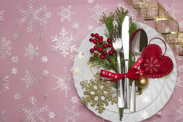 Weihnachtstisch gedeckt mit Tannenzweigen, Schleife und Schleife. Hintergrund Weihnachtsurlaub. — Stockfoto