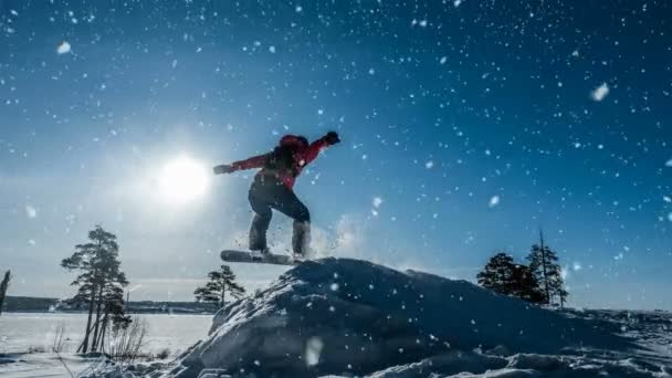 Cinemagraph. Novis snowboardåkare i ett hopp med lätt snö språngbräda, vinterlandskap, videoslinga — Stockvideo