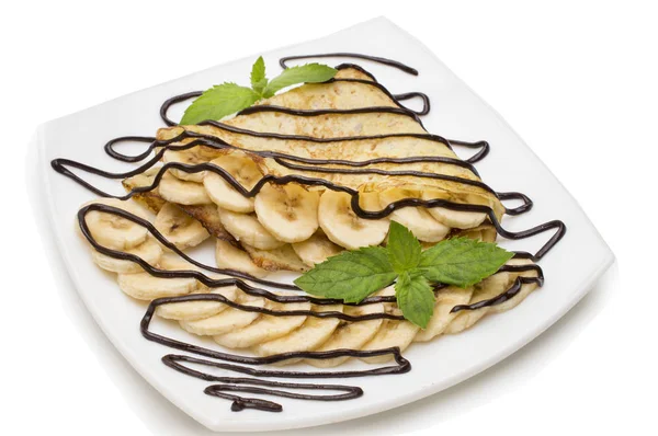 Krem çikolata ve beyaz arka plan üzerinde muz krep.