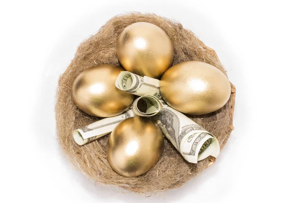 Nid avec des œufs dorés sur fond blanc. Œufs d'or dans le nid avec de dollars — Photo