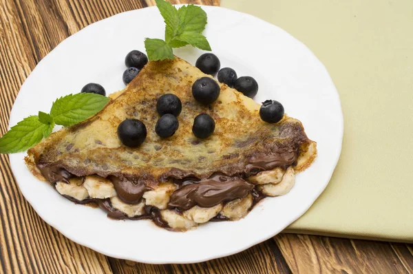 Crepes caseiros servidos com mirtilos frescos e açúcar em pó na mesa de madeira rústica — Fotografia de Stock