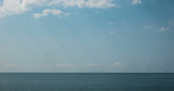 Na piękny letni dzień, czyste błękitne wody i gładkie fale, Błękitne niebo z chmurami, linii horyzontu z widokiem na morze. Morze, ocean natura timelapse tła wideo. — Wideo stockowe