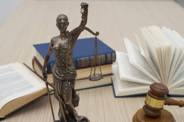 Statua della giustizia, i giudici martellano dietro i libri su un tavolo di legno — Foto Stock