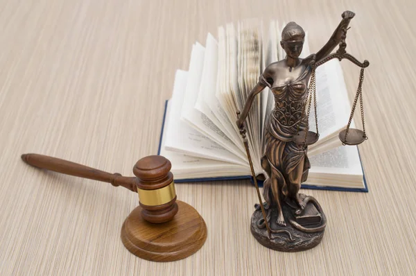 Statue of justice, judges hammer behind books on a wooden table. Top — Stock Photo, Image