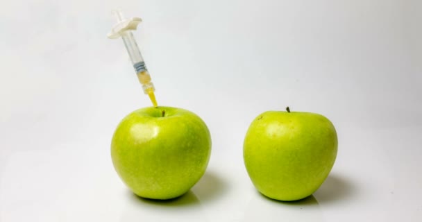 Una manzana fresca con una jeringa y una manzana en descomposición durante, vueltas de tiempo, el concepto de ralentizar el envejecimiento utilizando métodos médicos y químicos — Vídeos de Stock