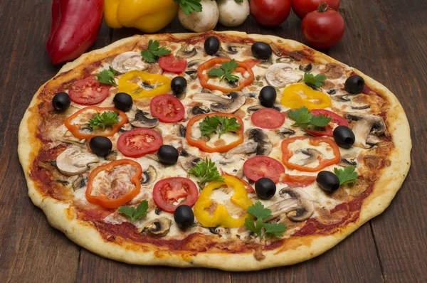 Pizza met ham, peper en olijven. Heerlijke Italiaanse pizza's op een houten achtergrond — Stockfoto