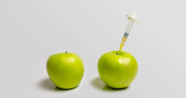 Свежее яблоко со шприцем и разлагающееся яблоко во время замедления старения с помощью медицинских и химических методов — стоковое видео