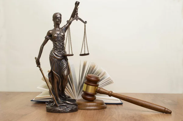 木製テーブルの上の本の背後にある裁判官ハンマー正義の女神像 — ストック写真