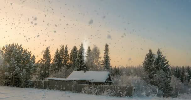 Une petite cabane en rondins près de la forêt, une belle chute de neige au coucher du soleil, un beau paysage hivernal. boucle vidéo, cinématographie — Video