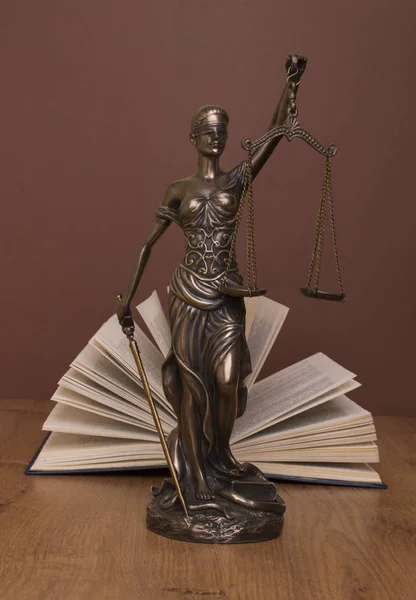 Statue of justice, judges hammer behind books on a braun background — Stock Photo, Image