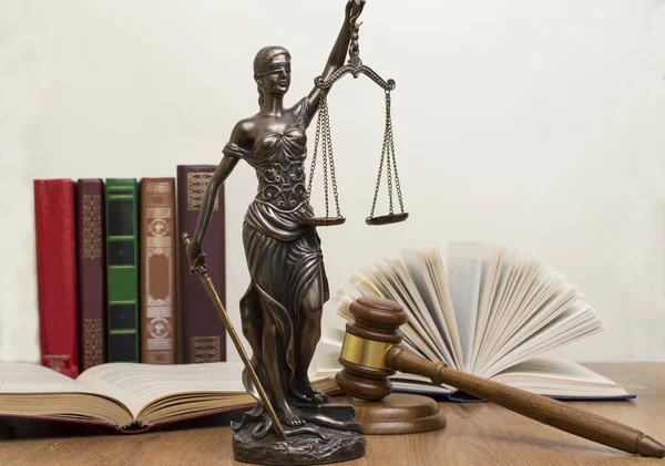 Ahşap masa arka planı açık bir kitap adalet heykeli. — Stok fotoğraf