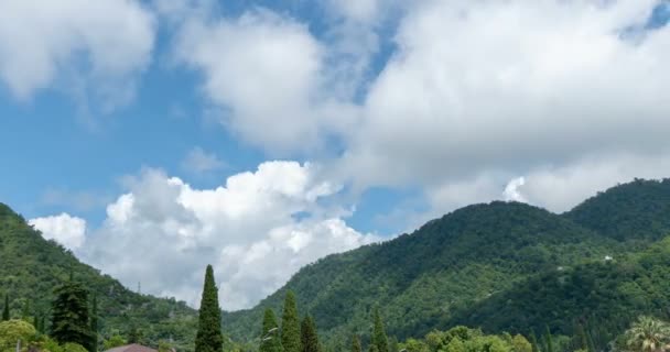 Ein kleines Dorf in den Bergen mit schönen Kumuluswolken, ein sommerlicher Zeitraffer in den Bergen, eine wunderschöne Berglandschaft — Stockvideo