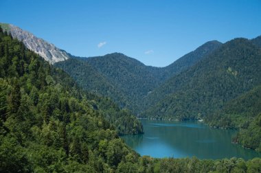 Dağların önünde dağ gölünün panoramik manzarası.