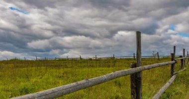 Mavi gökyüzünün altında, cirrus bulutları ile saman balyaları ile stubble alanı. 4k zaman atlamalı 4096x2160