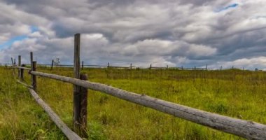 Mavi gökyüzünün altında, cirrus bulutları ile saman balyaları ile stubble alanı. 4k zaman atlamalı 4096x2160