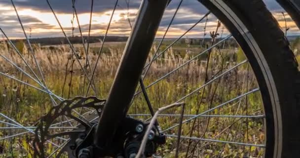 Movimiento de la cámara a lo largo de la bicicleta contra el sol poniente, hermoso paisaje, lapso de tiempo, hiperlapso — Vídeo de stock