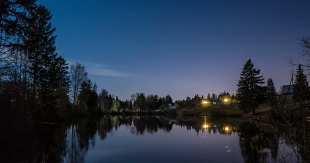 Млечный Путь и звездное время проходят над спокойным озером с силуэтами деревьев — стоковое видео