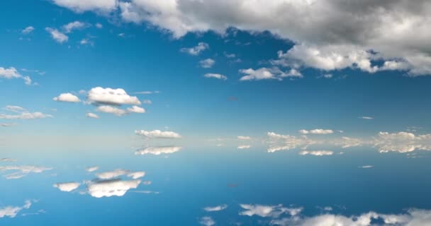 Futuristic background consisting of Time lapse clip of white fluffy clouds over blue sky and their reflection, video loop — Stock Video