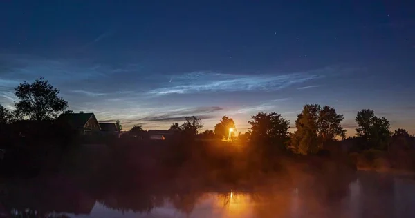 Cometa C 2020 F3 NEOWISE nel cielo notturno con nuvole argentee, un bellissimo intervallo notturno Foto Stock Royalty Free