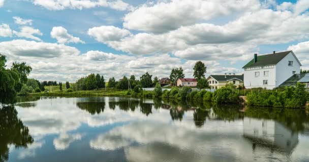 村景与小湖交相辉映，云朵在水面反射，夏景秀丽 — 图库视频影像
