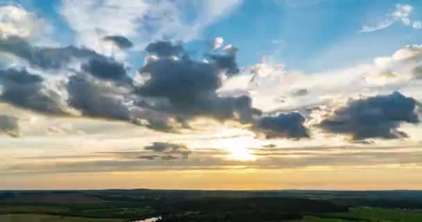 Hermoso atardecer, lapso de tiempo, movimiento de nubes de un nivel diferente contra el sol poniente, rayos del sol a través de las nubes, movimiento de la cámara a la izquierda. — Vídeos de Stock