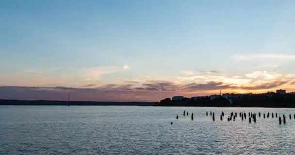 Ohromující panoramatický výhled na záliv proti obzoru se západem slunce a oranžovou oblohou pod těžkými pohybujícími se mraky. Zpomalená scenérie. Slunce nad mořským zálivem — Stock video