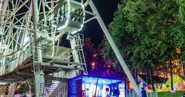 밤에 놀이 공원, 테마파크, 공정, 스릴 파크 4k 에서 회전하는 밝게 빛나는 페리스 휠타기 시간 감소 — 비디오