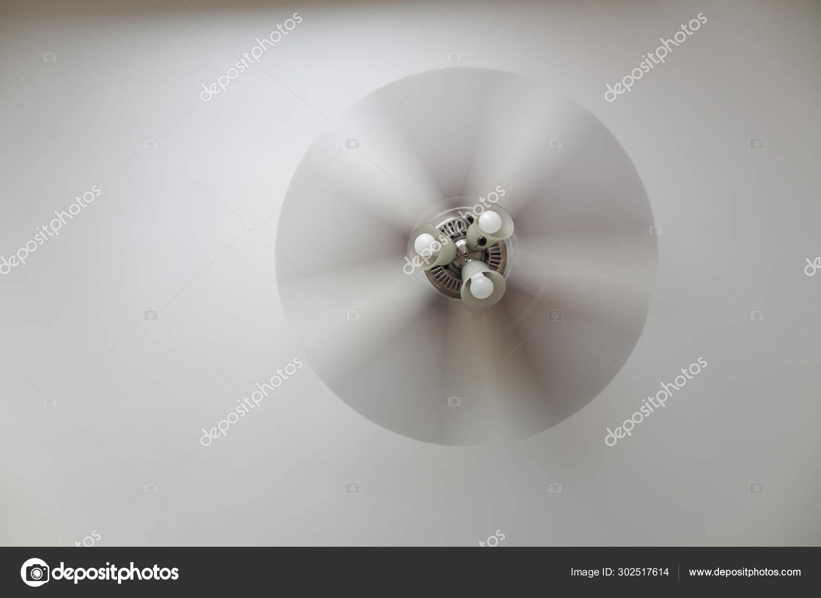 Ceiling Fan With A Ceiling Lamp Turned On Working With Blurred
