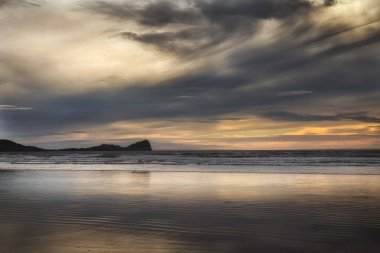 Gün batımı bulutlar Rhossili Bay ve solucanlar baş Gower yarımadasındaki, Swansea, South Wales, İngiltere