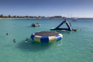 Editoryal Barbados, Karayipler - 25 Ocak 2019: Bridgetown, Barbados, Karayipler'de bir plajda şişme su trambolin ve slayt